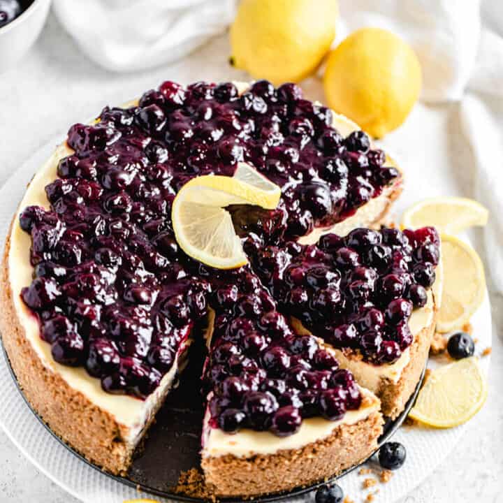 half sliced cheesecake on a white platter