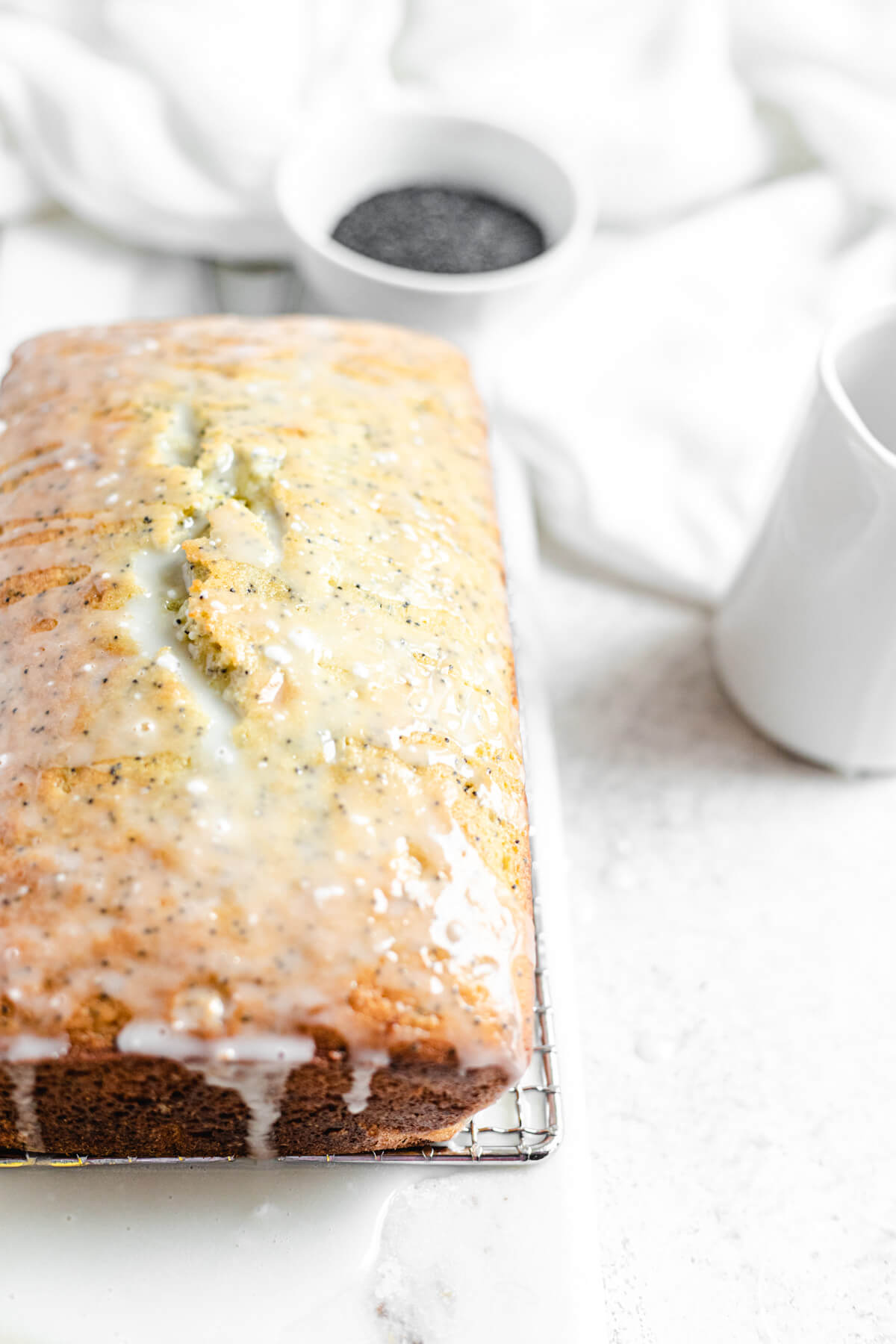 glazed loaf on a safety grater with a bowl of poppy seeds in the background