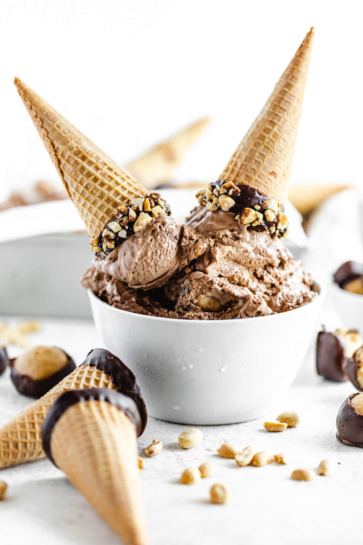 ice cream in a white bowl with two cones on top of it facing upside down