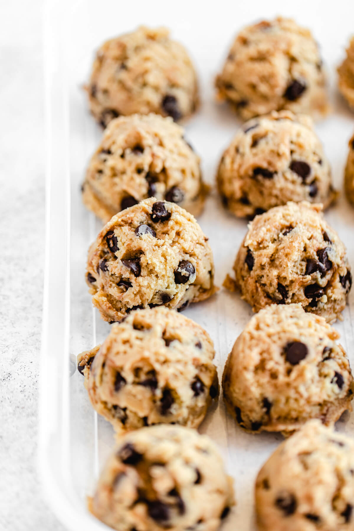 scooped cookie dough lined up in a plastic container