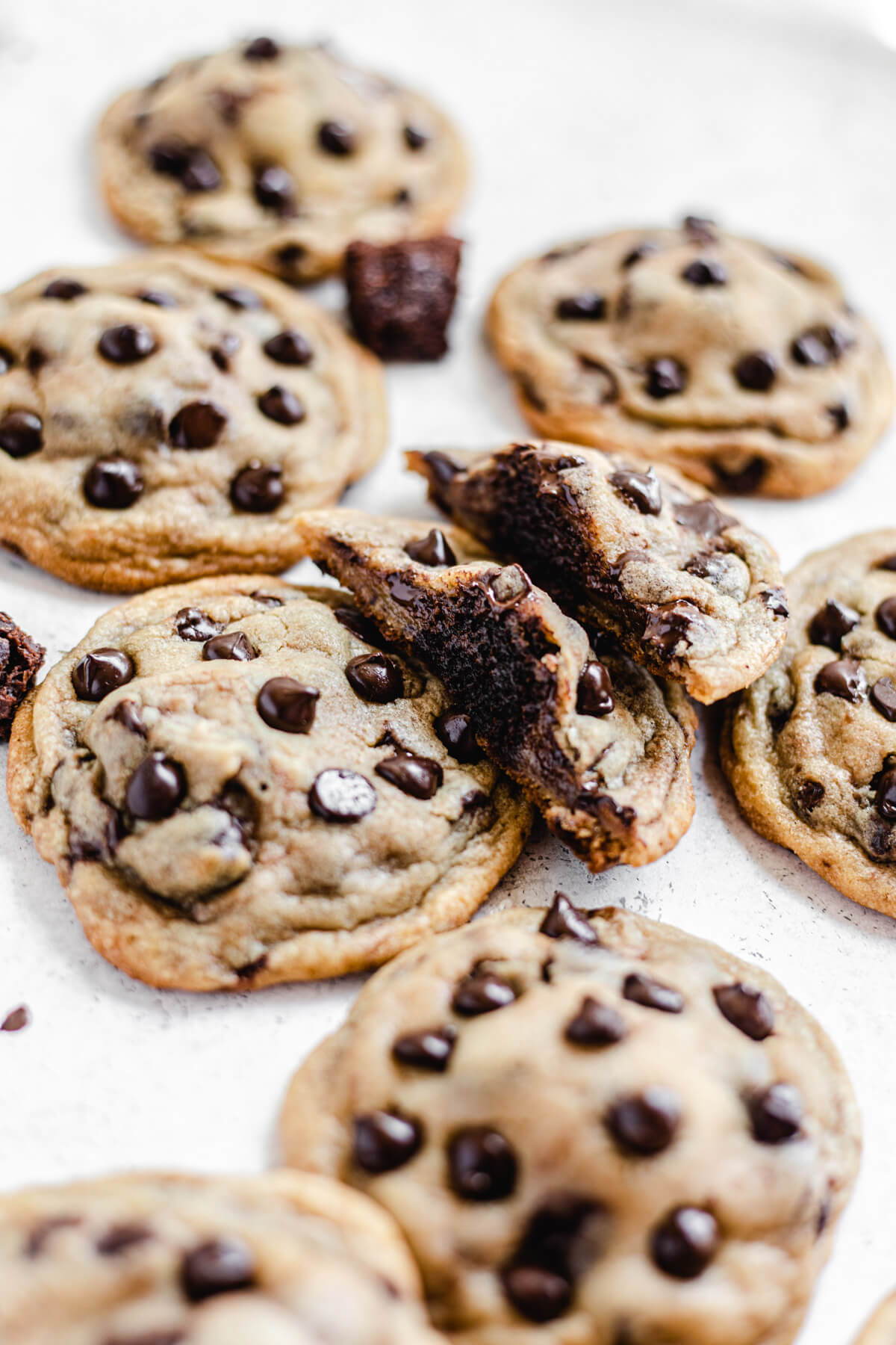 two halves of a cookie leaning on a chocolate chip cookie