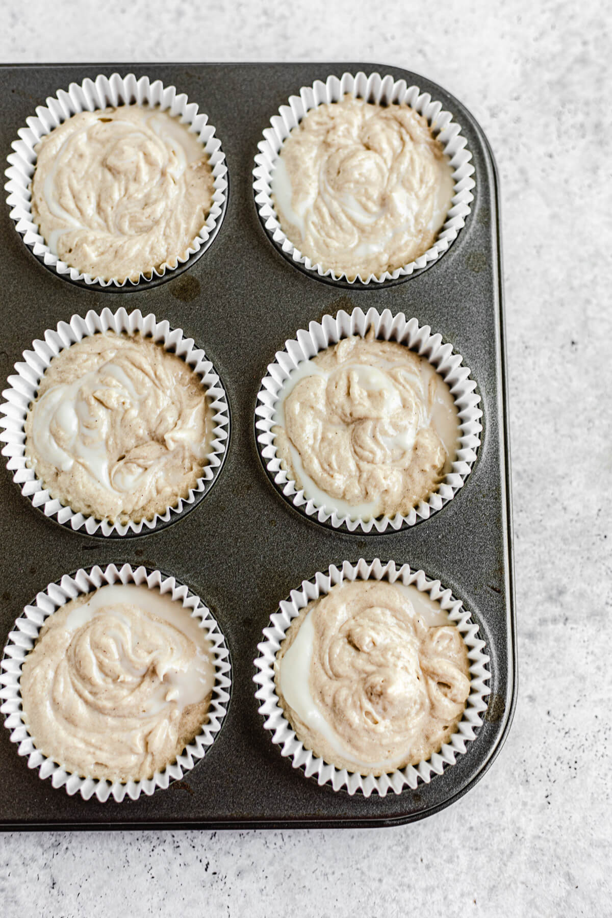 cheesecake swirled cupcake batter in cupcake pan