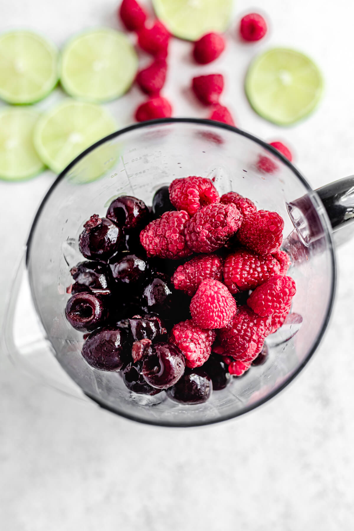 top view of cherries and raspberries inside a blender