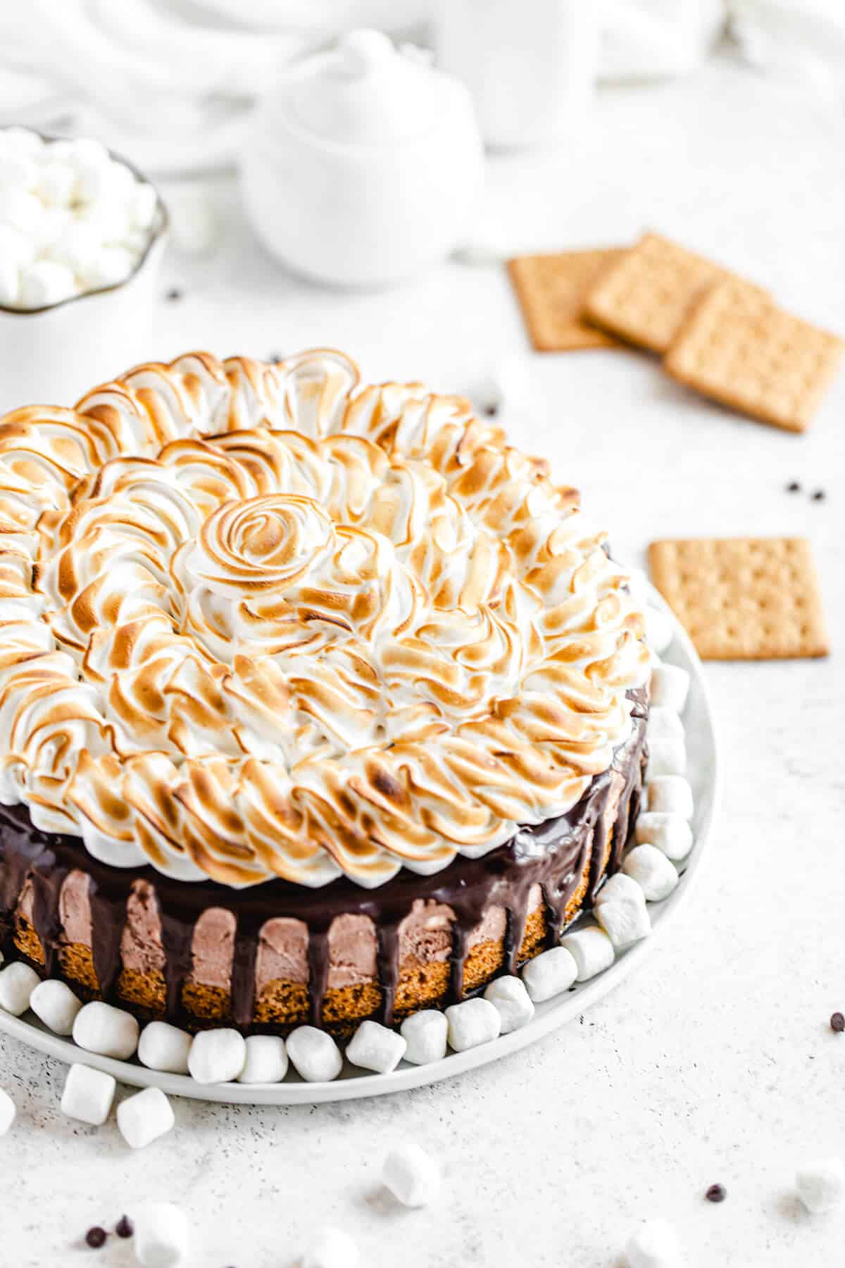 ice cream cake on a white platter with mini marshmallows on the bottom of it