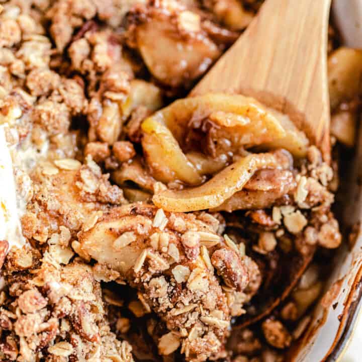 close up of apple crisp with wooden spoon digging in