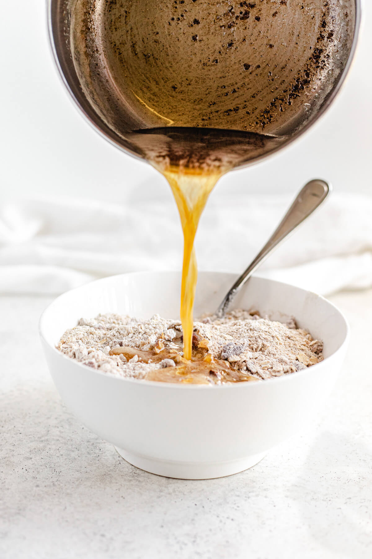 pouring browned butter into crumble mixture