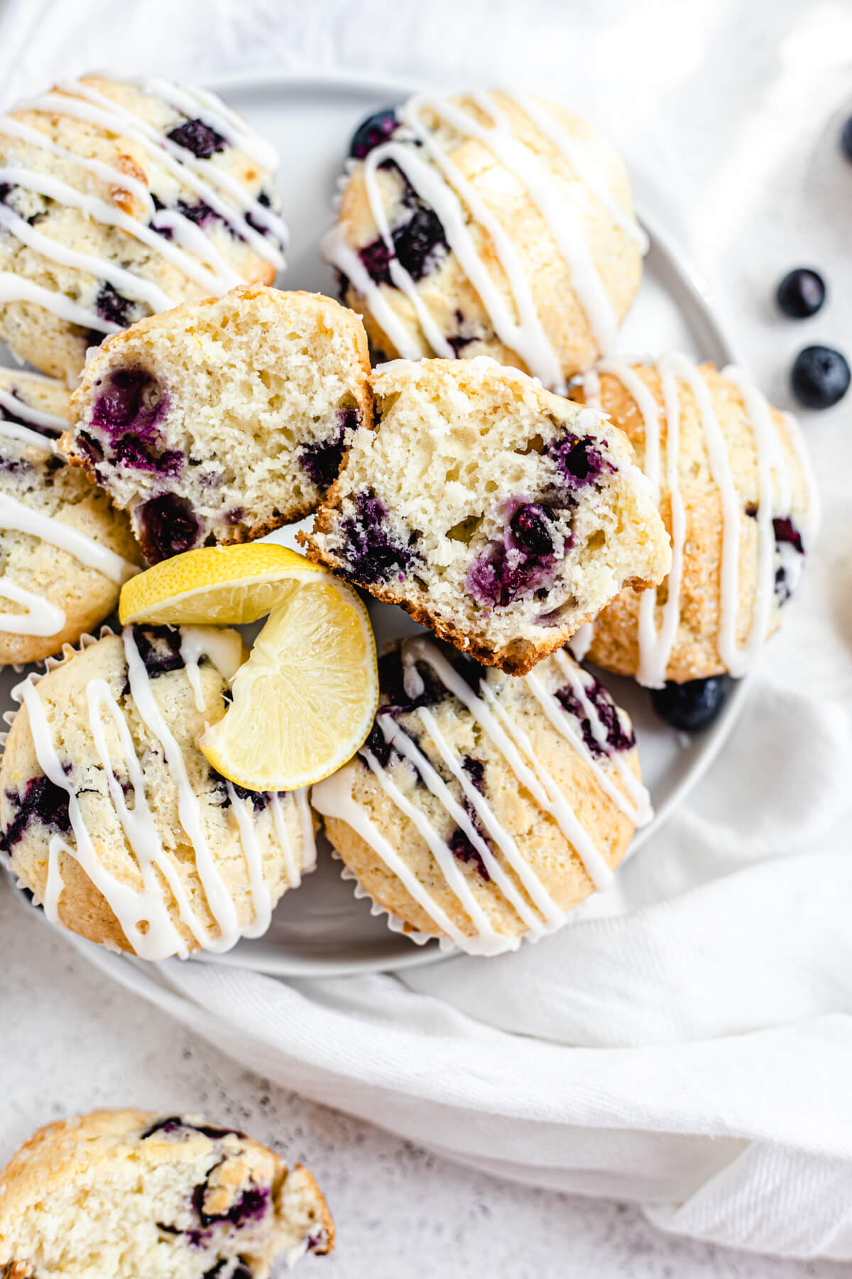 top view of muffins on a white plate with halved muffins on the top