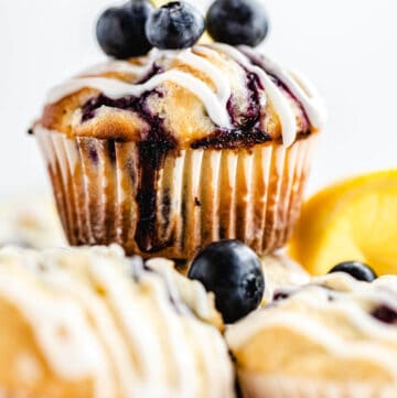 close up of blueberry muffin on top of other muffins
