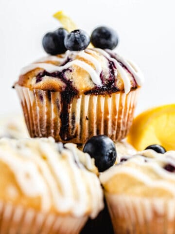close up of blueberry muffin on top of other muffins