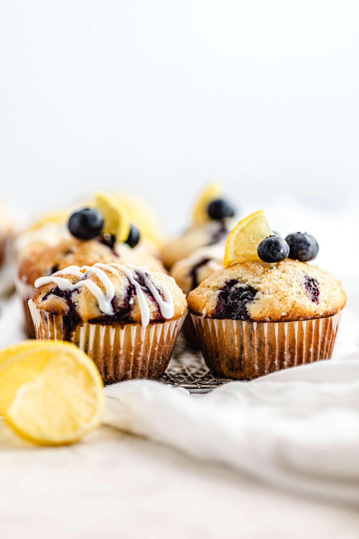 blueberry muffins lined up on a safety grater with lemon twist in front of them