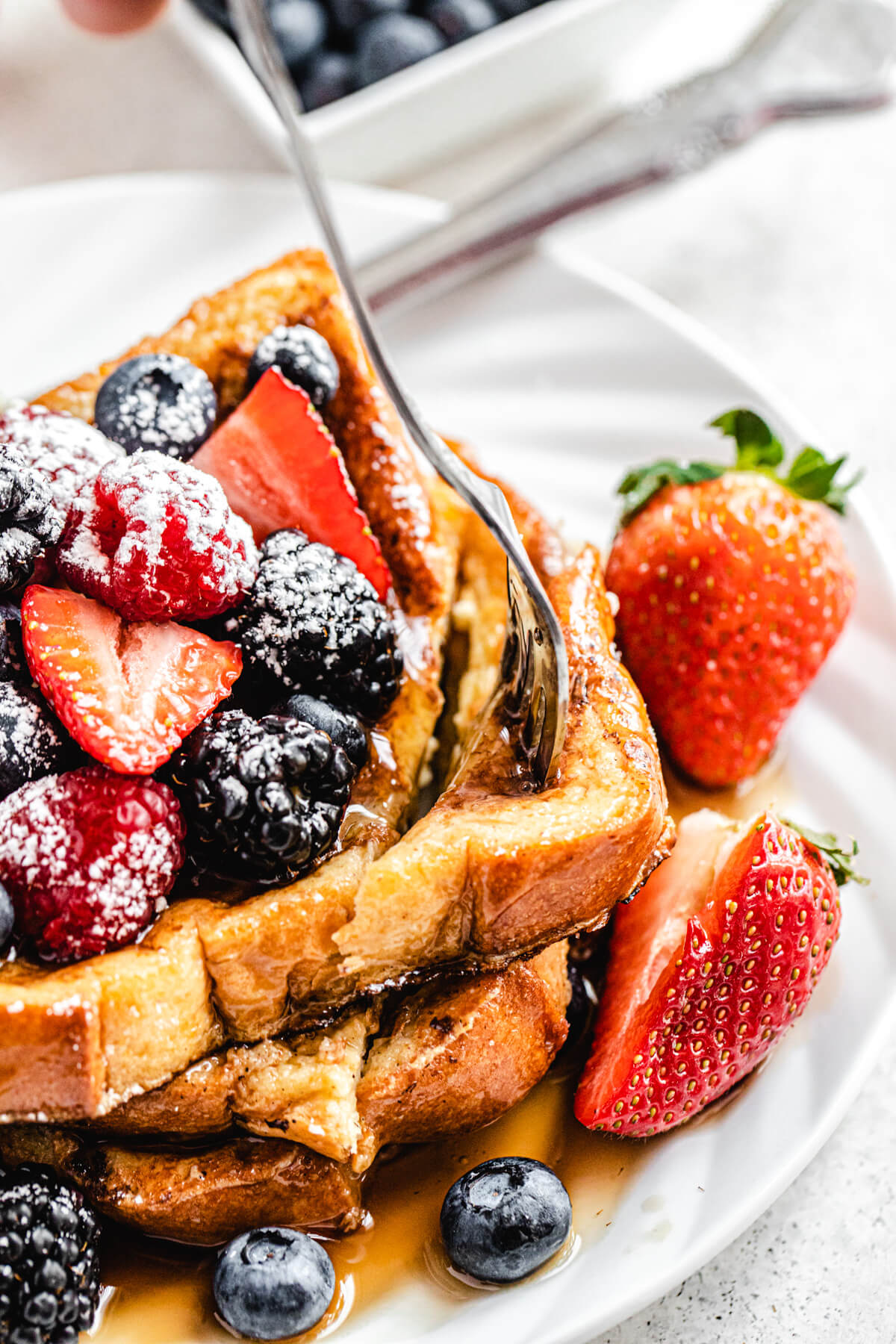 close up of French toast on a plate with fork inside