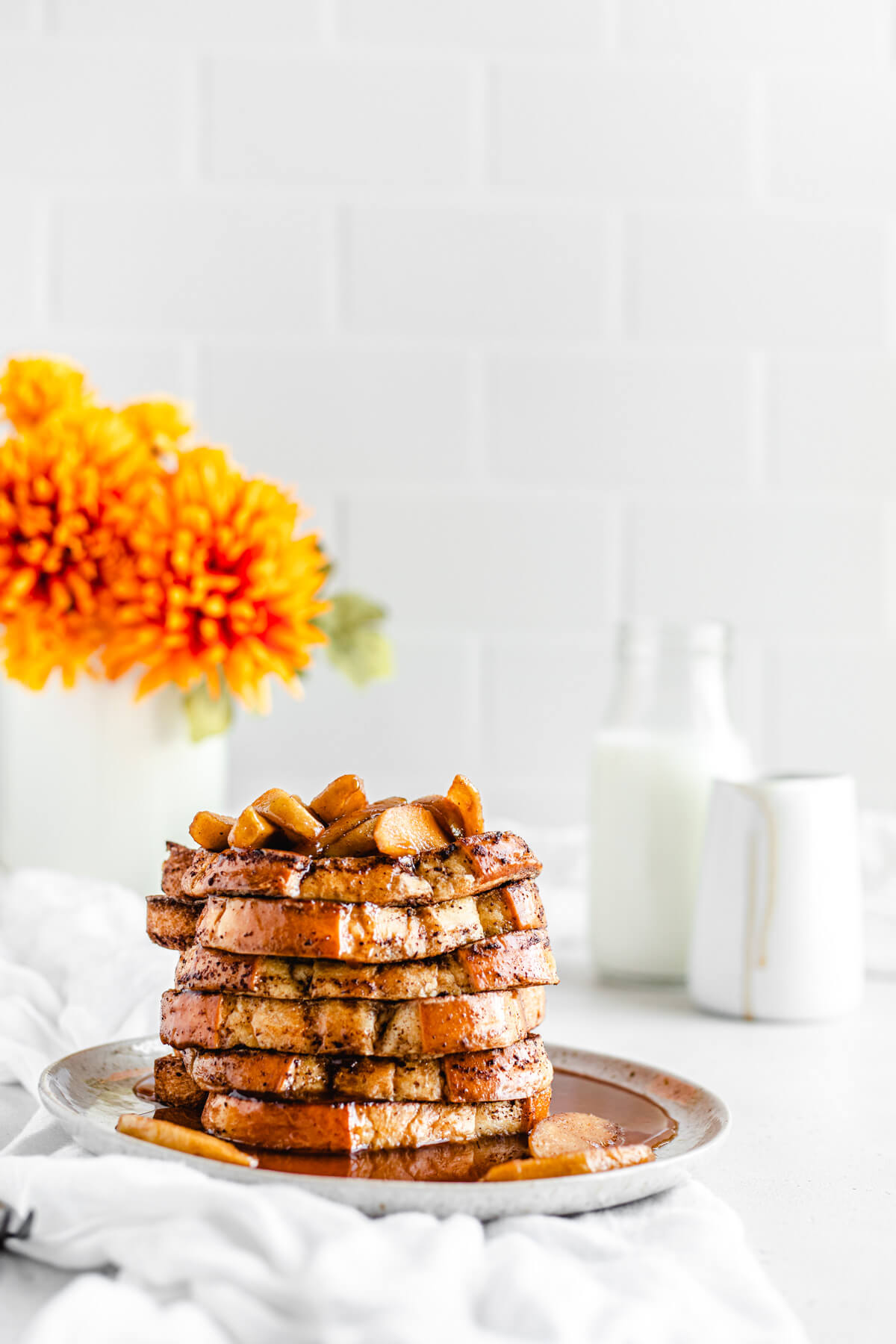 a stack of French toast on a plate topped with apples