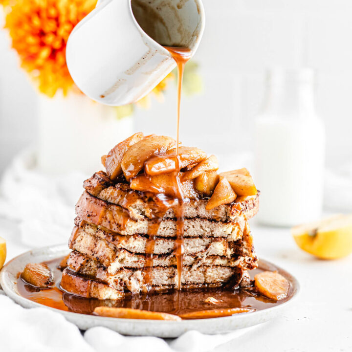 pouring syrup onto sliced stack of French toast