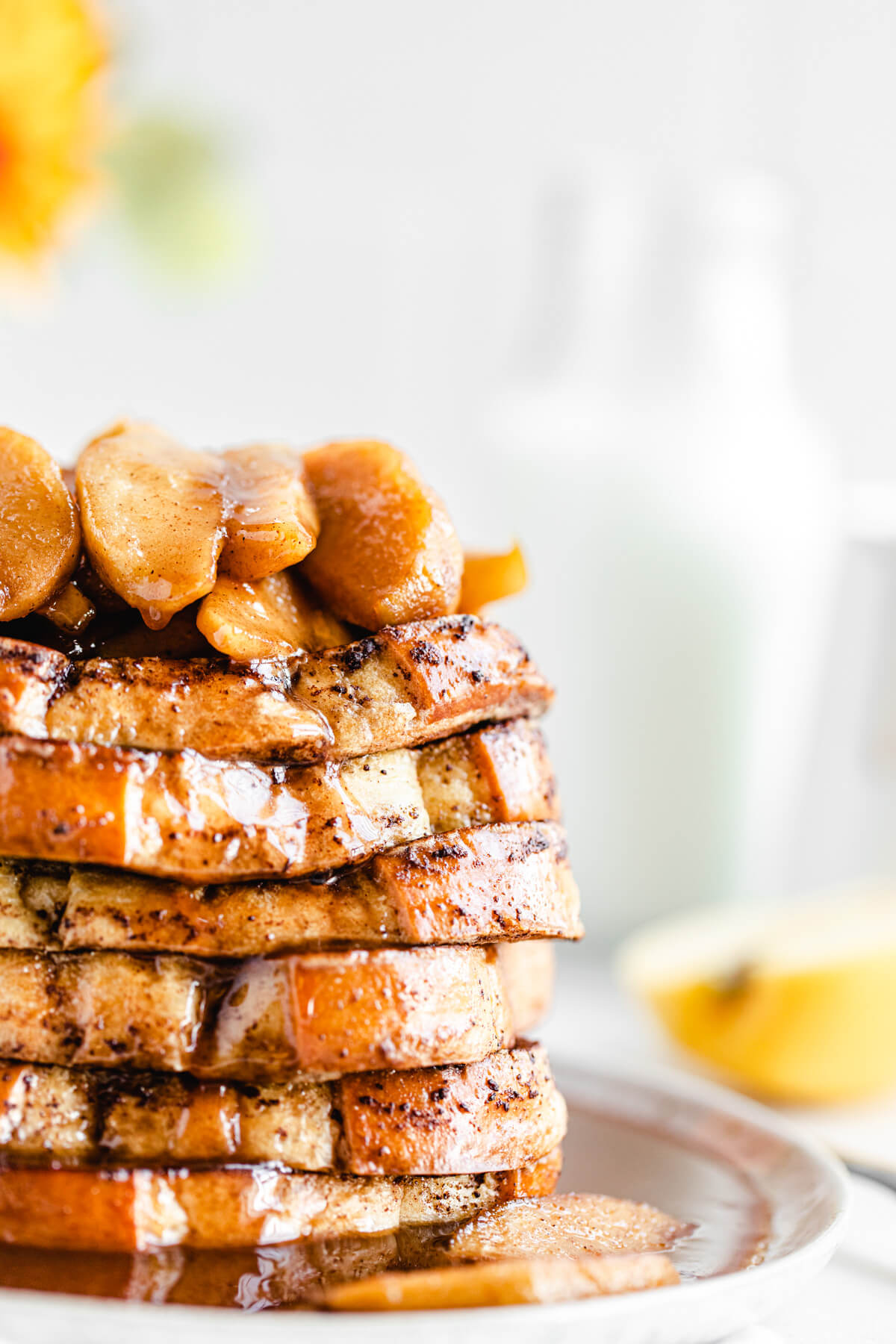 close up of apple topped French toast stacked on a plate