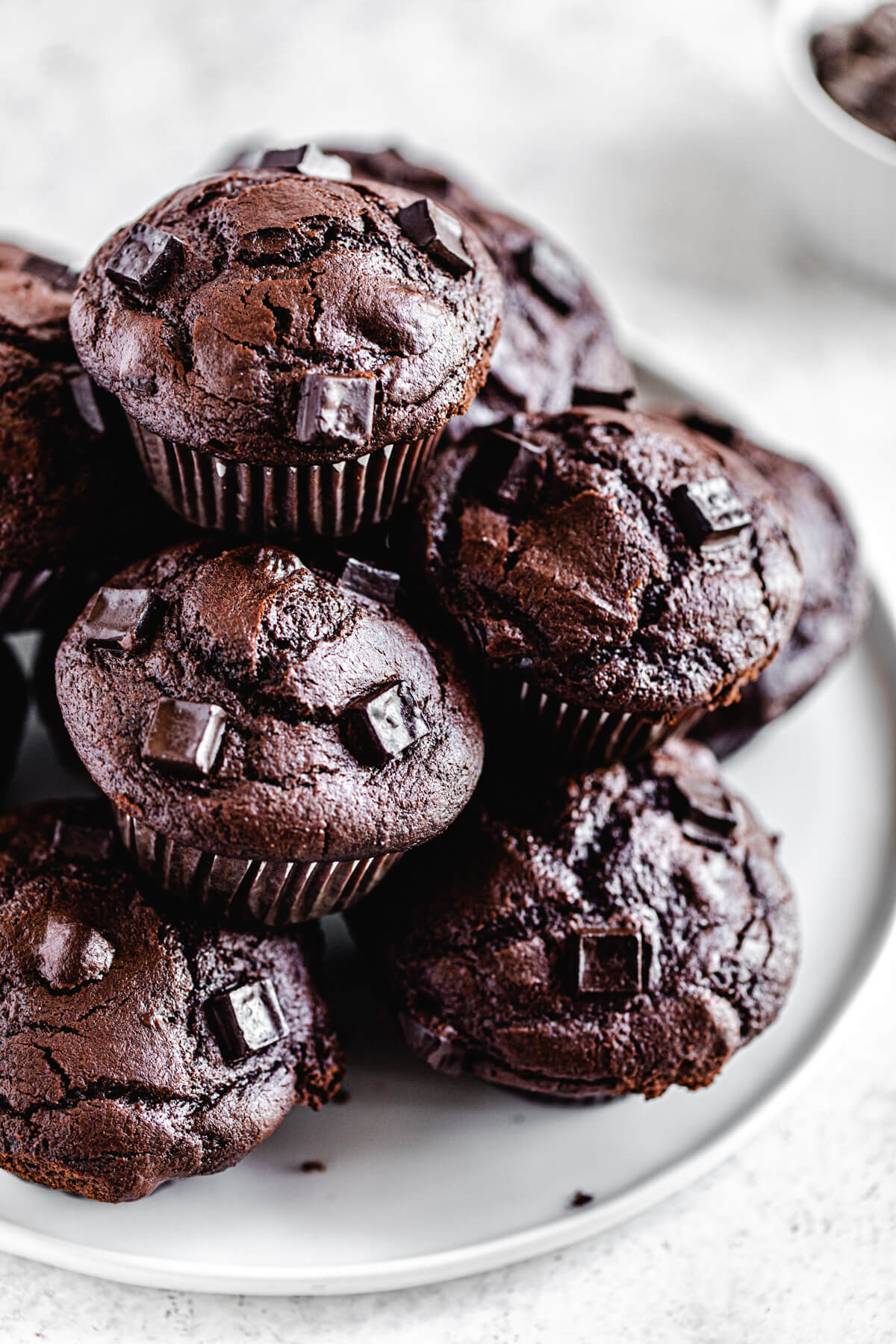 close up of muffins stacked in a pyramid on a white plate