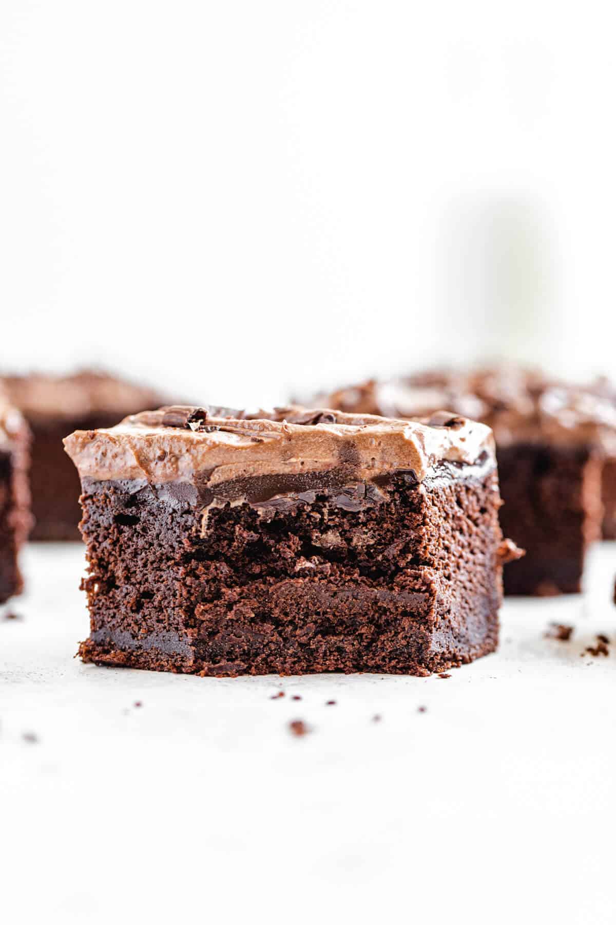 half eaten slice of chocolate cake in the foreground with multiple slices in the background