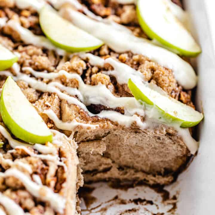 close up of cinnamon rolls in a dish with front roll removed