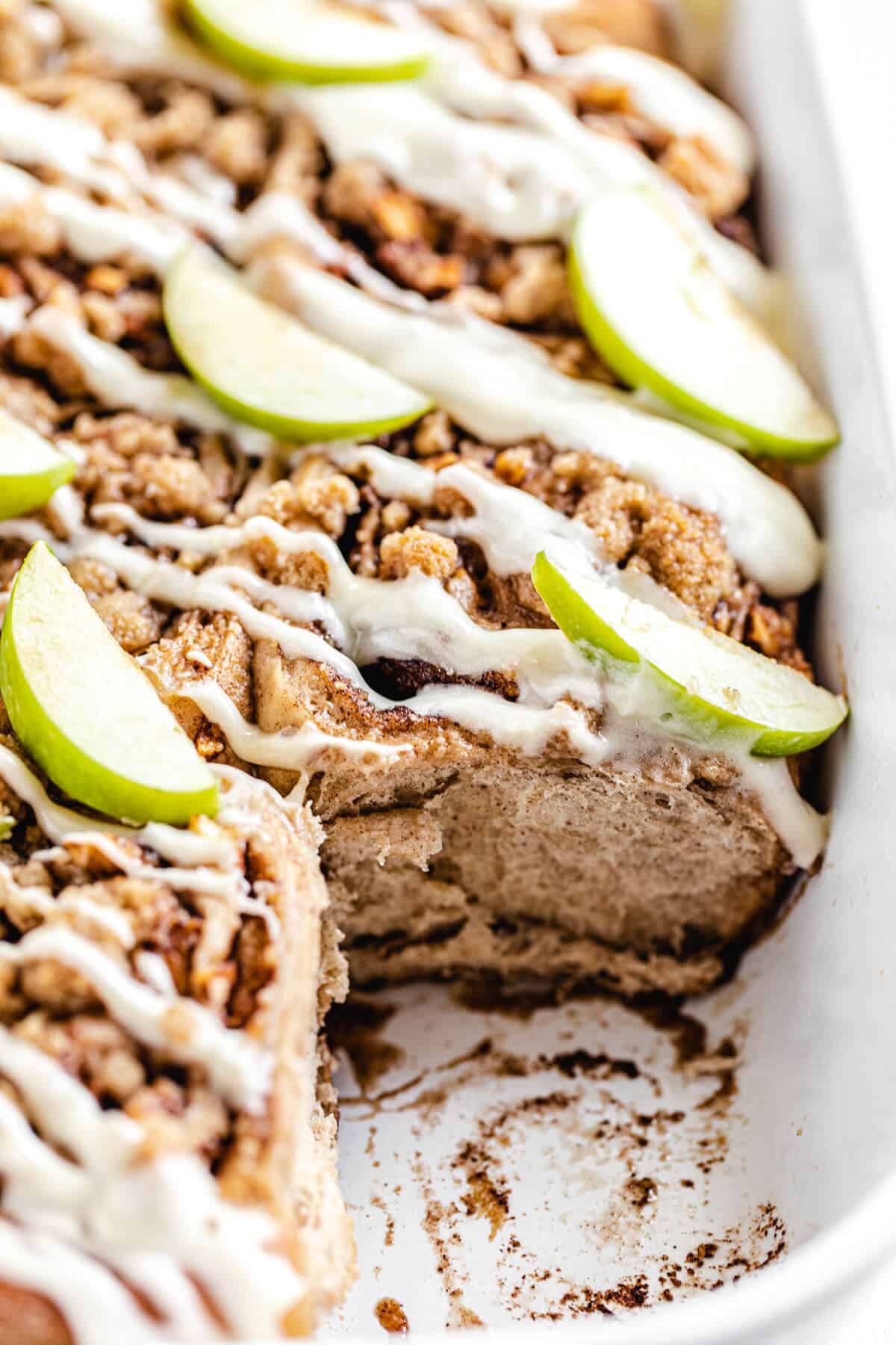 close up of cinnamon rolls in a dish with front roll removed