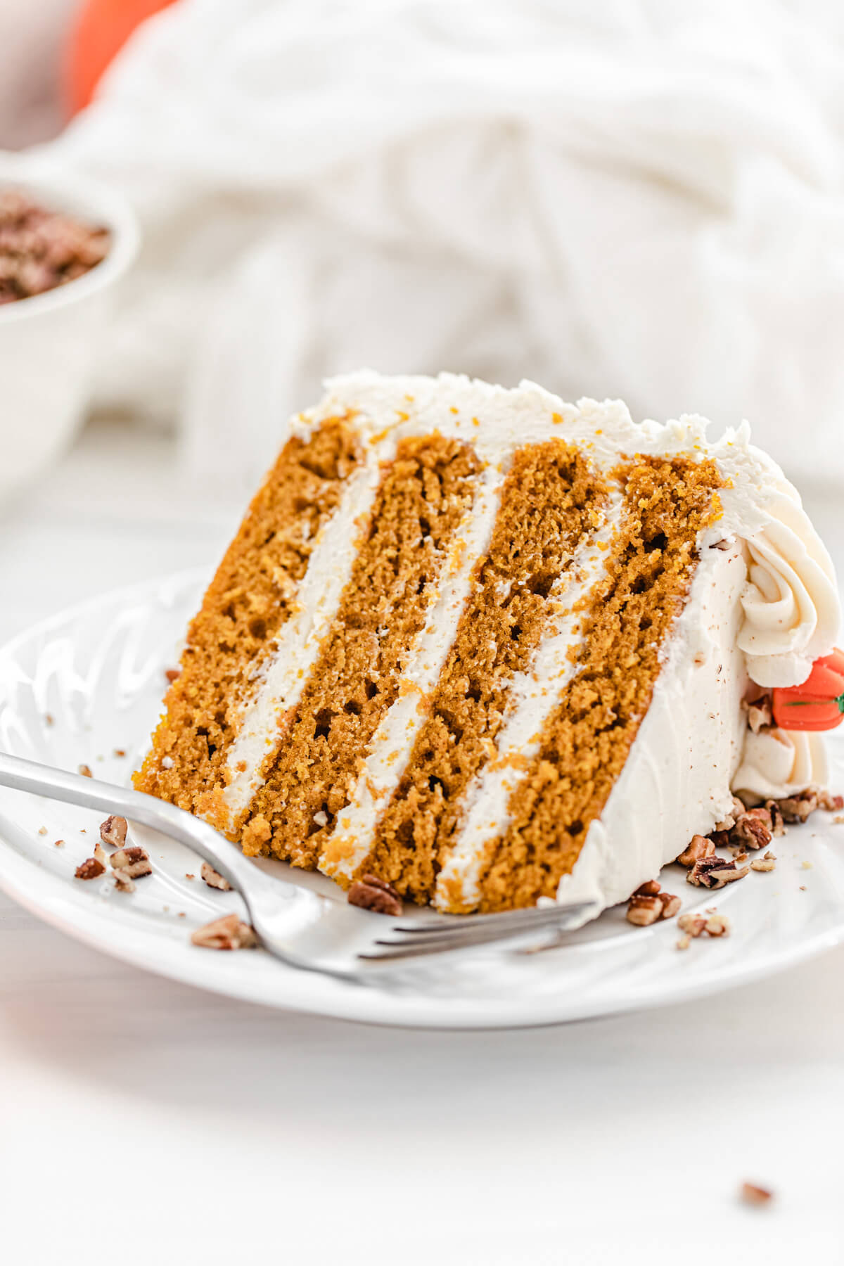 slice of pumpkin cake on a white plate with a fork on it