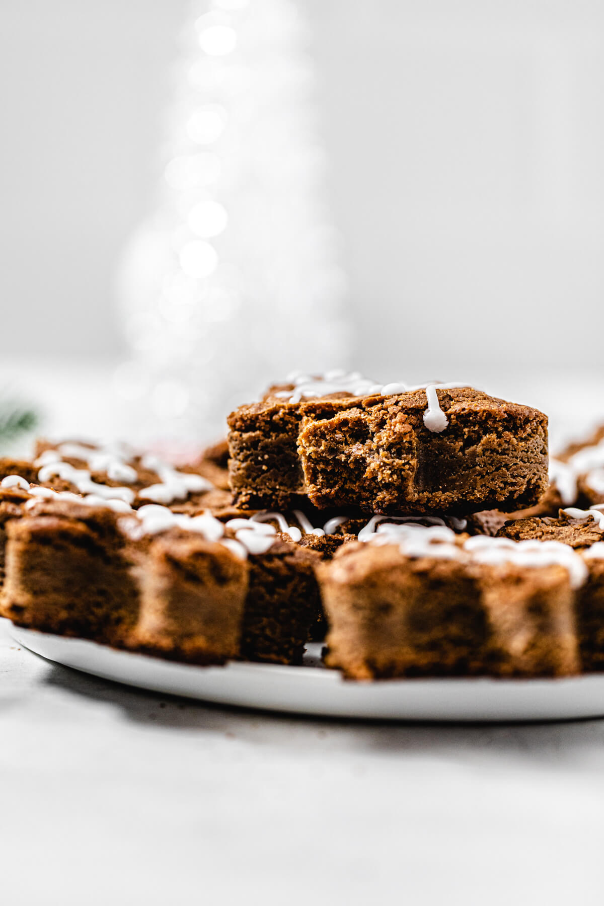 blondies on a white platter with a half eaten blondie stacked on top 