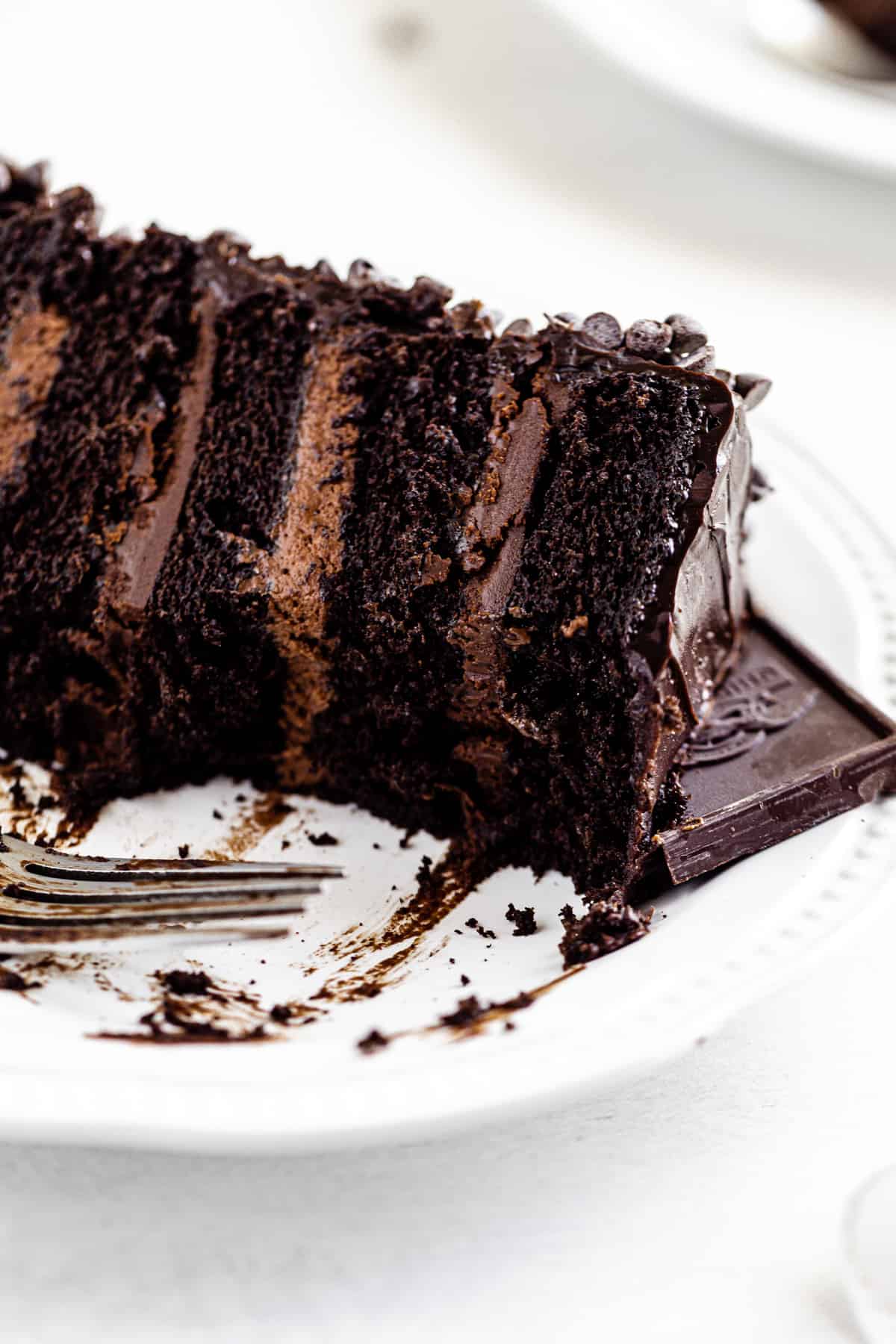 close up of half-eaten chocolate cake on a white plate