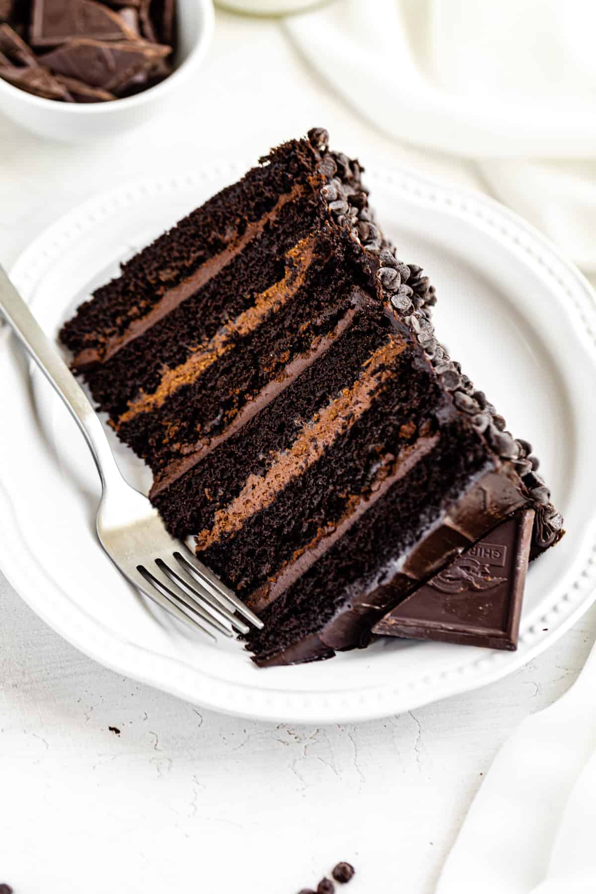 6-layer cake on a white plate with a fork next to it