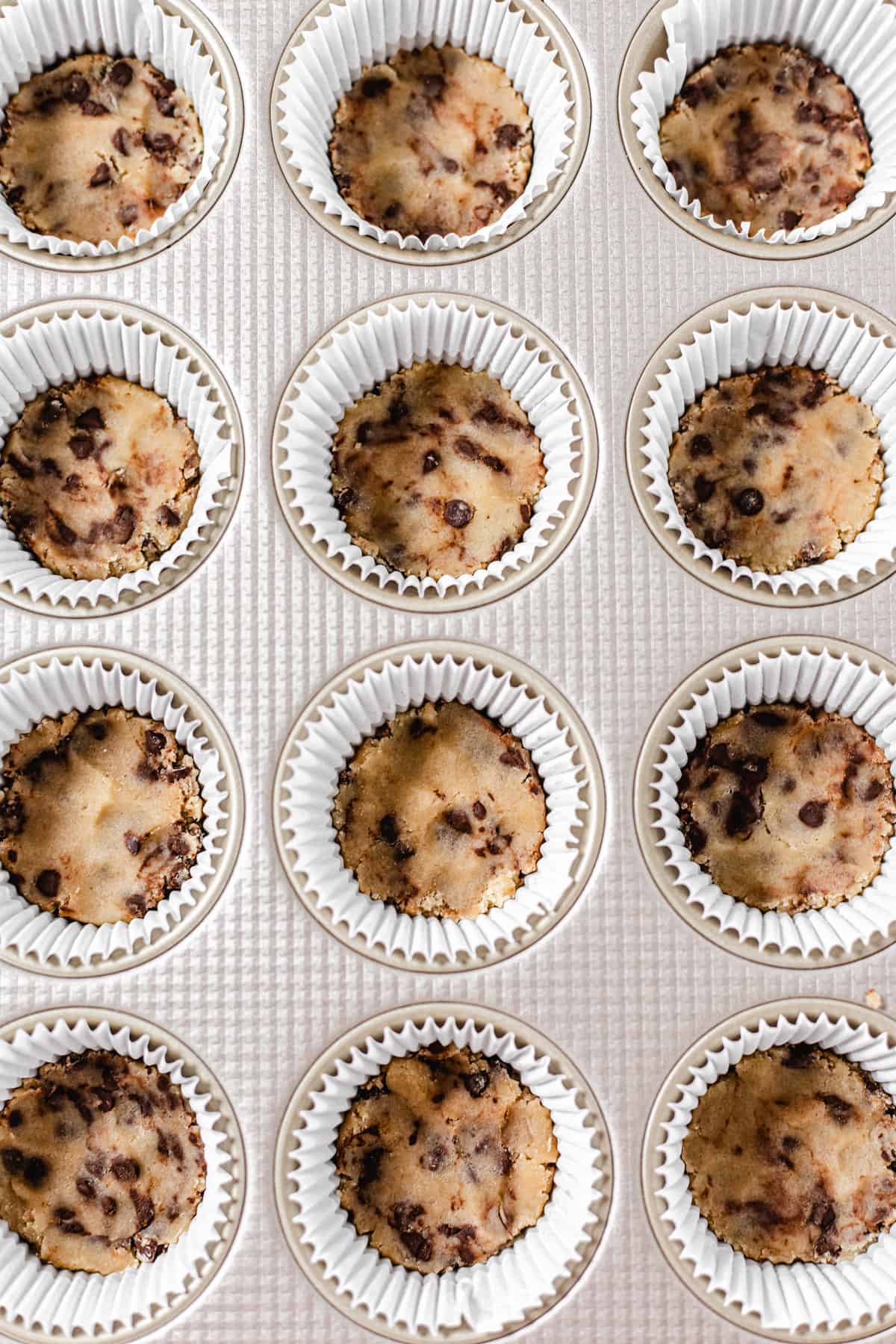 cookie dough inside cupcake liners inside a muffin pan