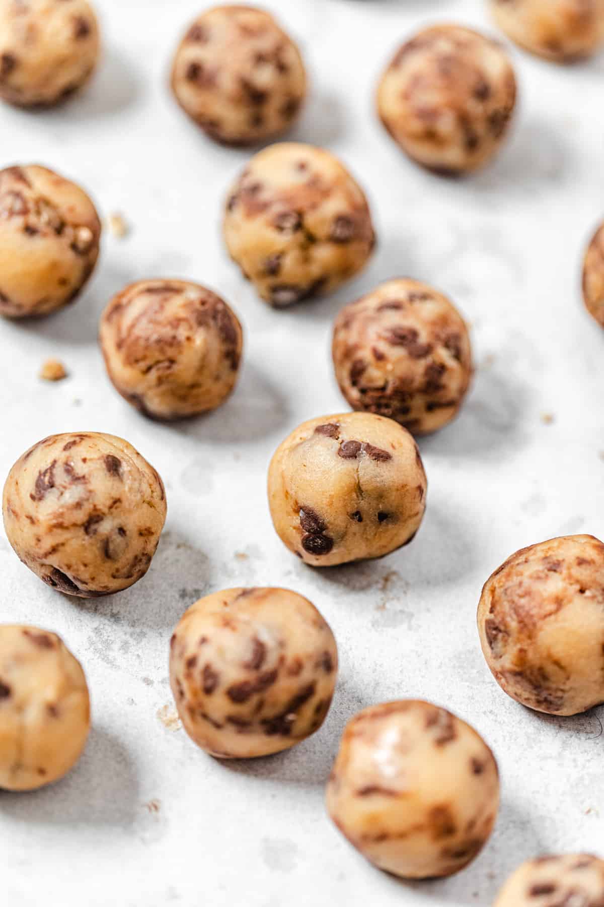 cookie dough balls on a parchment lined baking sheet