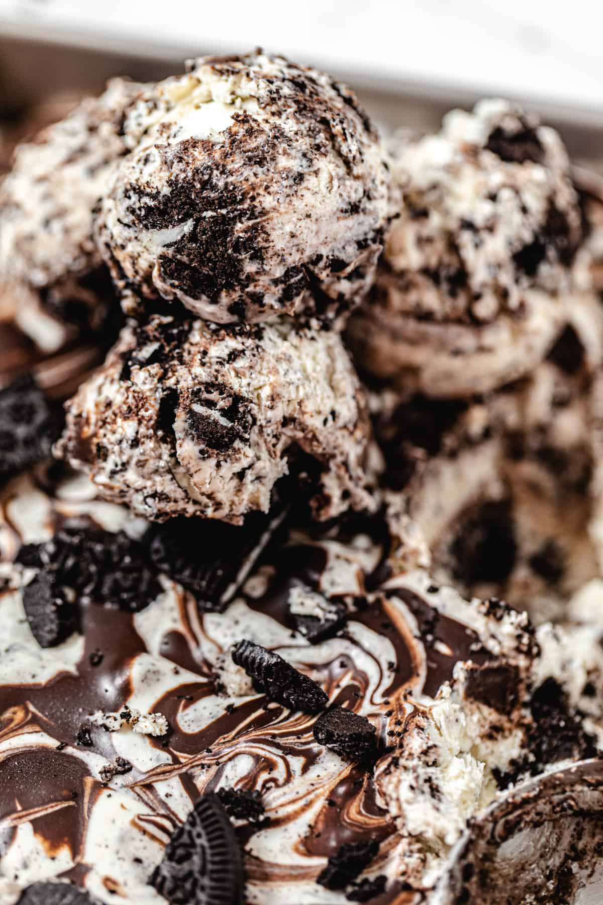 close up of three scoops of ice cream on top of pan of ice cream