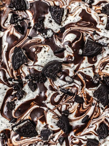 close up of the top of ice cream swirled with ganache and topped with Oreo pieces