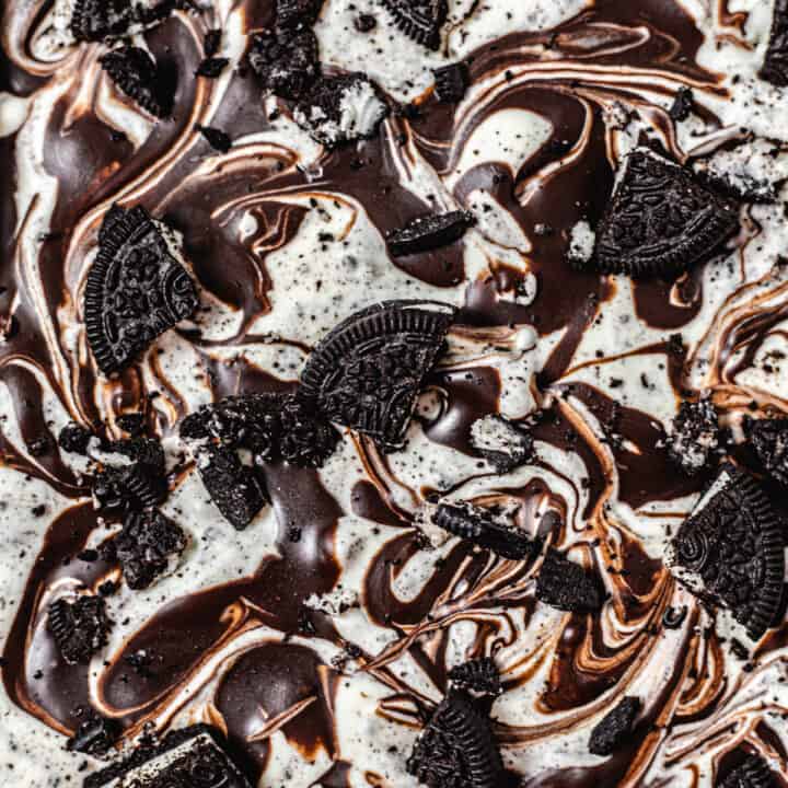 close up of the top of ice cream swirled with ganache and topped with Oreo pieces