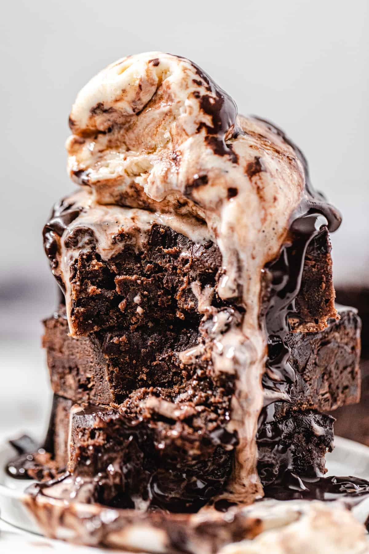 close up of a stack of brownies with scoops of vanilla ice cream on top