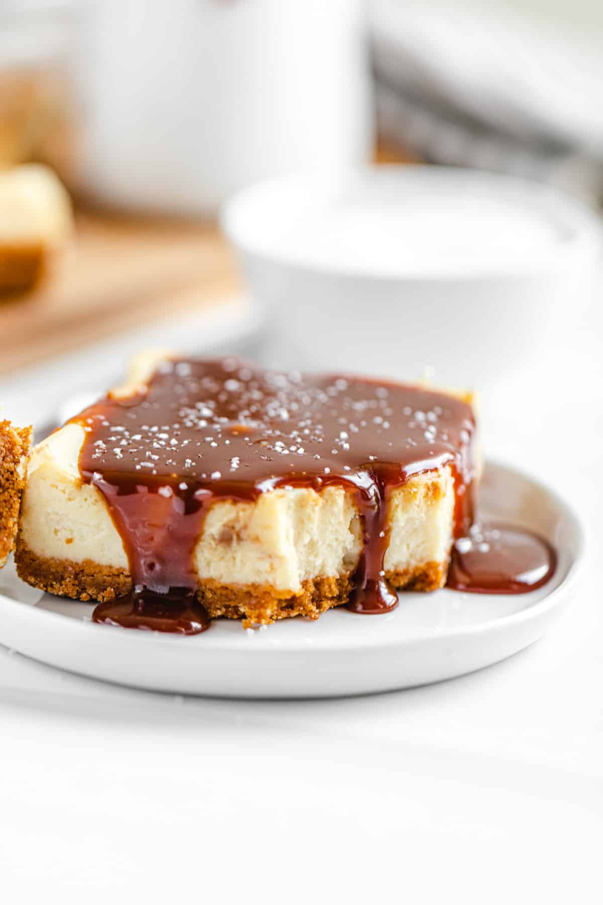 half-eaten caramel topped cheesecake bar on a small white plate