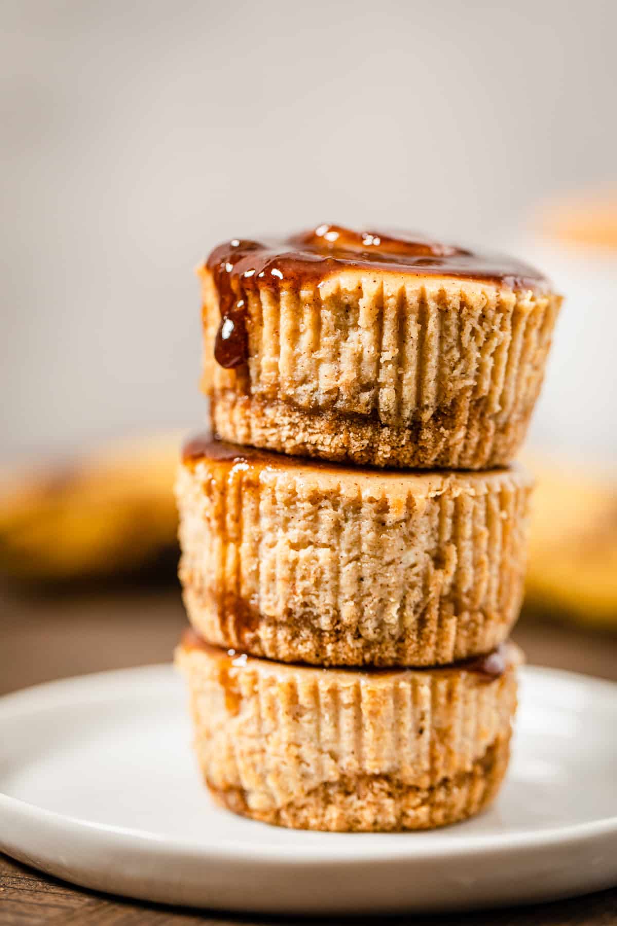 a stack of three cheesecake cupcakes on a small white plate