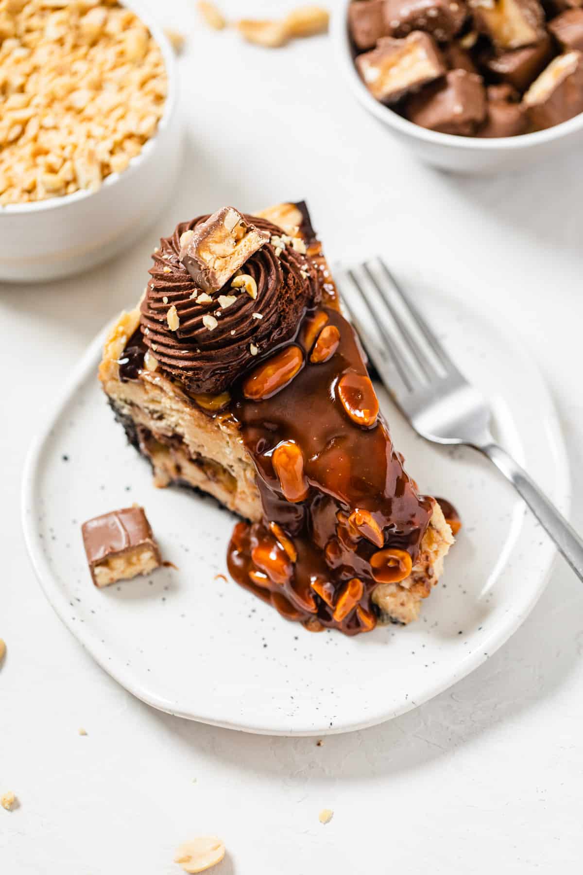 top view of a slice of cheesecake on a white plate with a fork next to it