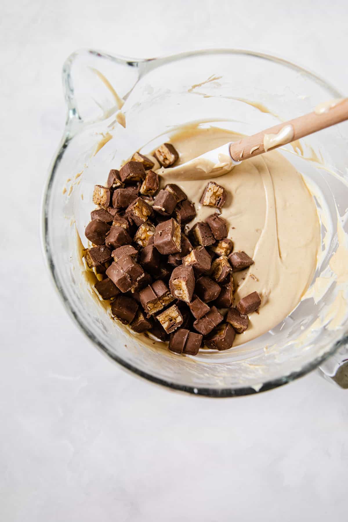 peanut butter cheesecake batter with chopped snickers