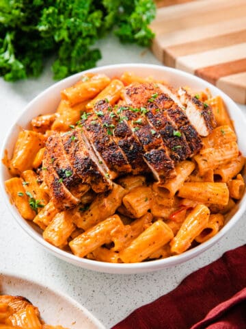 sliced chicken breast on a plate of pasta