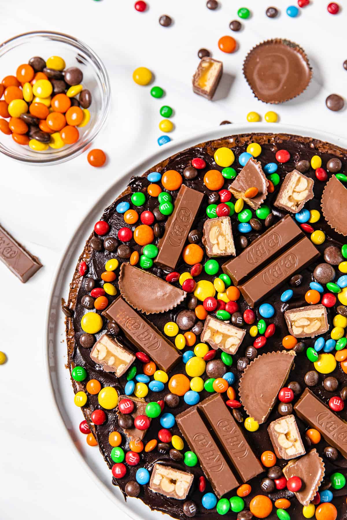 round brownie cake topped with ganache and candy