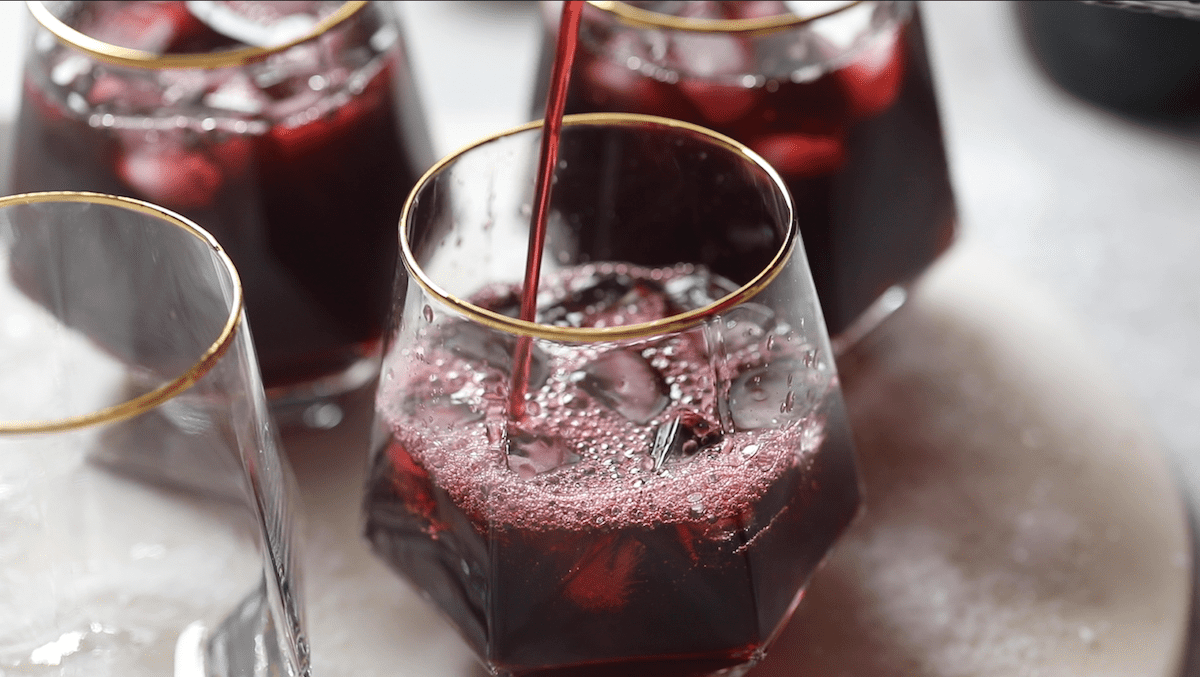 pouring sorrel into a glass filled with ice