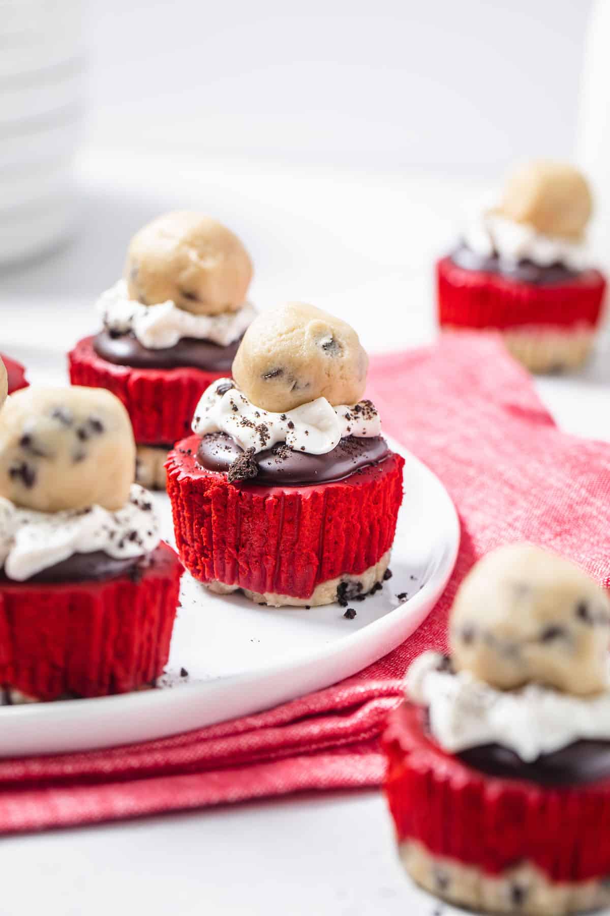 platter of mini red velvet cheesecakes with cookie dough on top