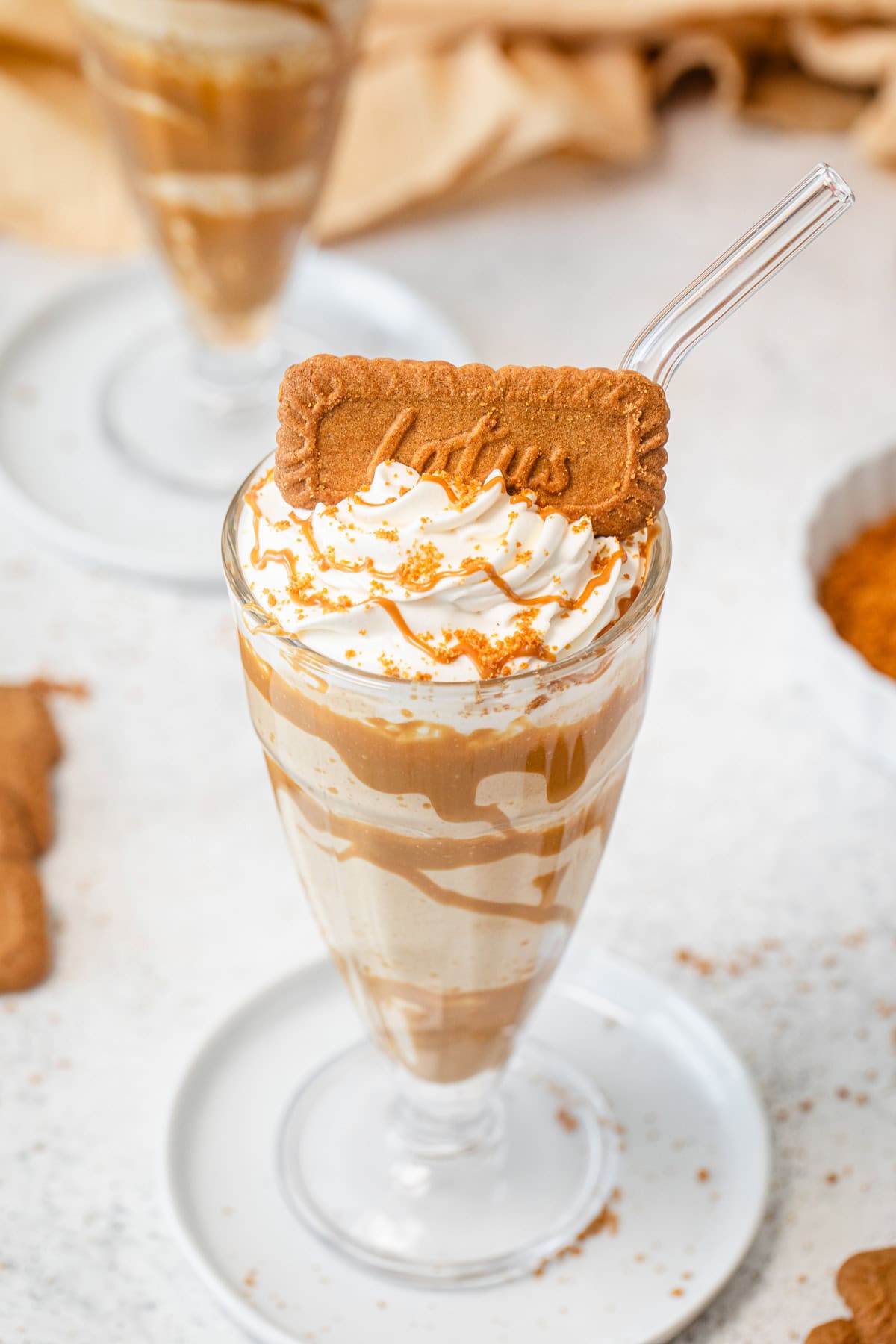 top angled picture of milkshake with whipped cream and a biscoff cookie on top
