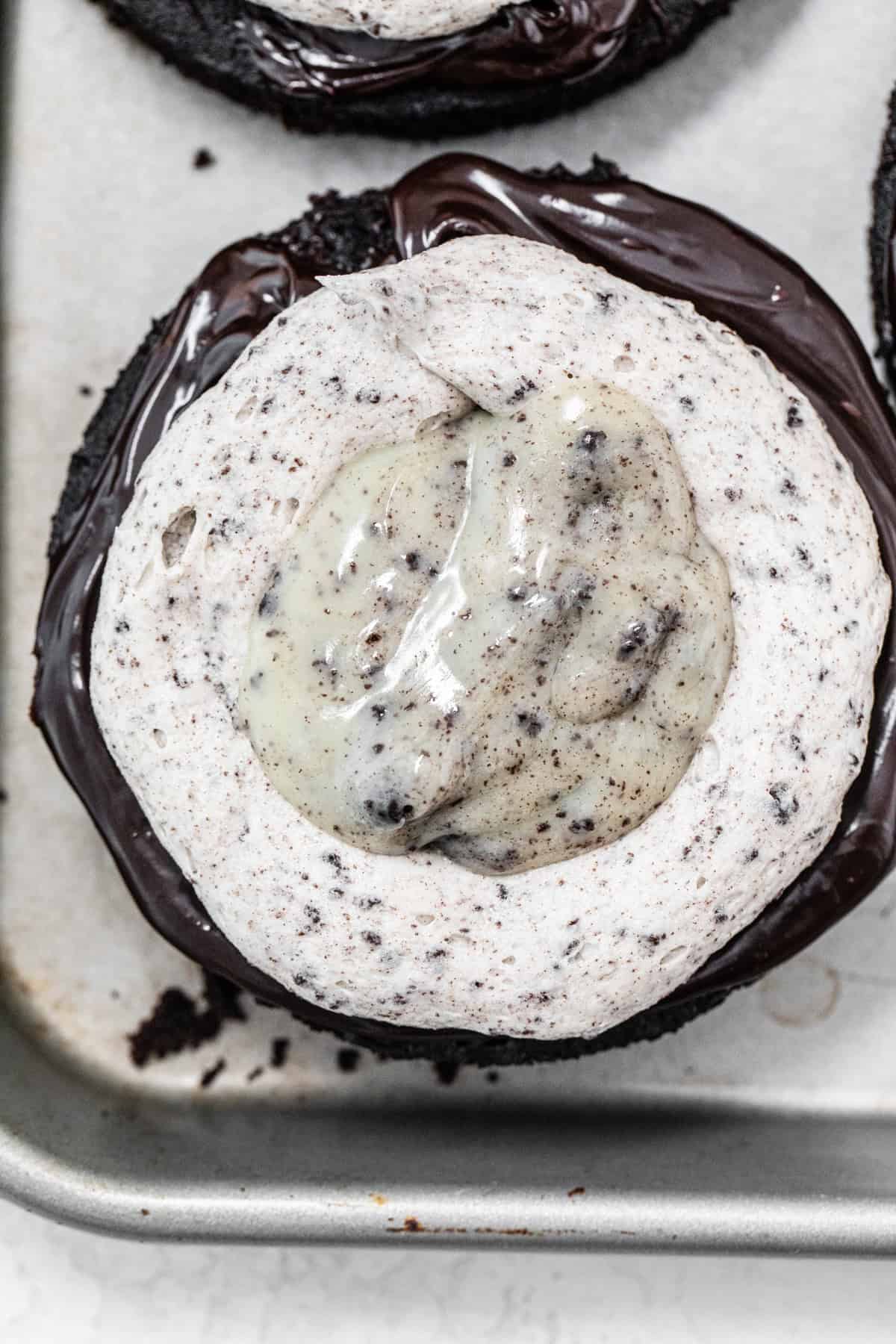 bottom layer of chocolate cake topped with a ring of cookies and cream frosting and filled with cookies and cream ganache
