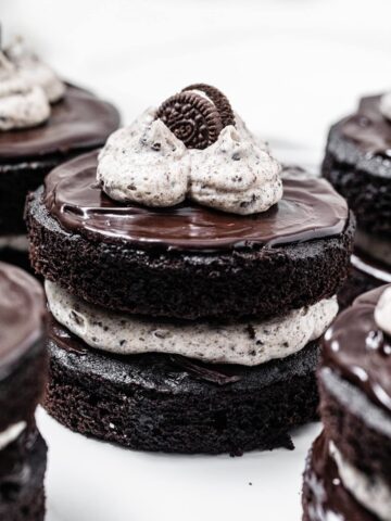 mini chocolate layer cake filled and topped with cookies and cream frosting, topped with ganache and a mini Oreo